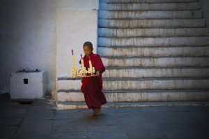 Small monk carrying the offering in Paro dzong